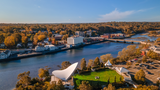 Aerial view of a waterfront town and riverside park in fall